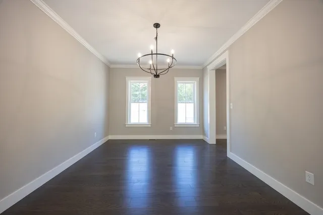 a view of empty room with wooden floor and window