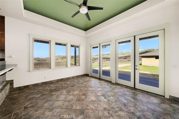 a view of a livingroom with a ceiling fan & entryway