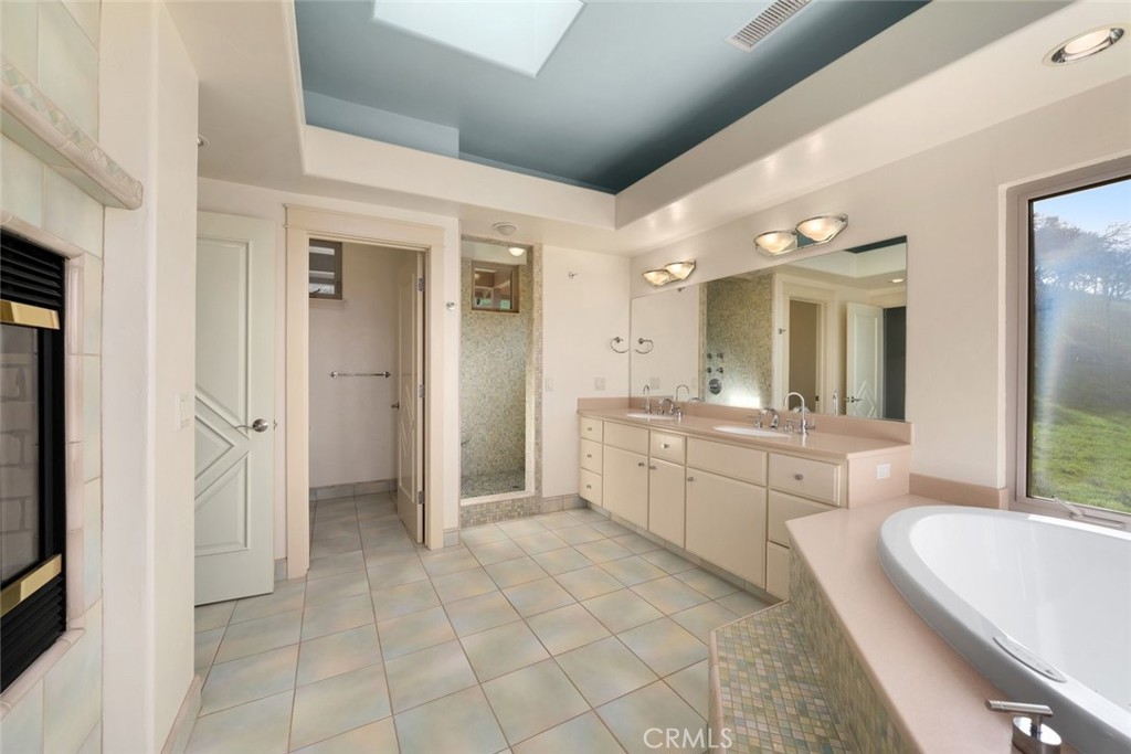 5840 Rocky Canyon Road Atascadero, CA 93422 - Photo 27 of 74 a large bathroom with a double vanity sink a mirror and a bathtub