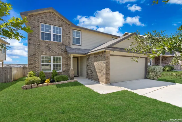 a front view of a house with a garden and yard