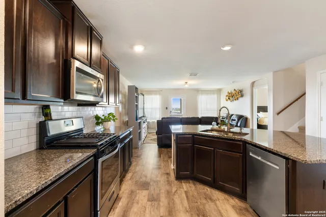 a kitchen with lots of counter top space a sink and stainless steel appliances