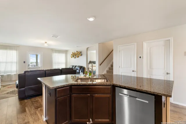 a kitchen with a sink cabinets and wooden floor