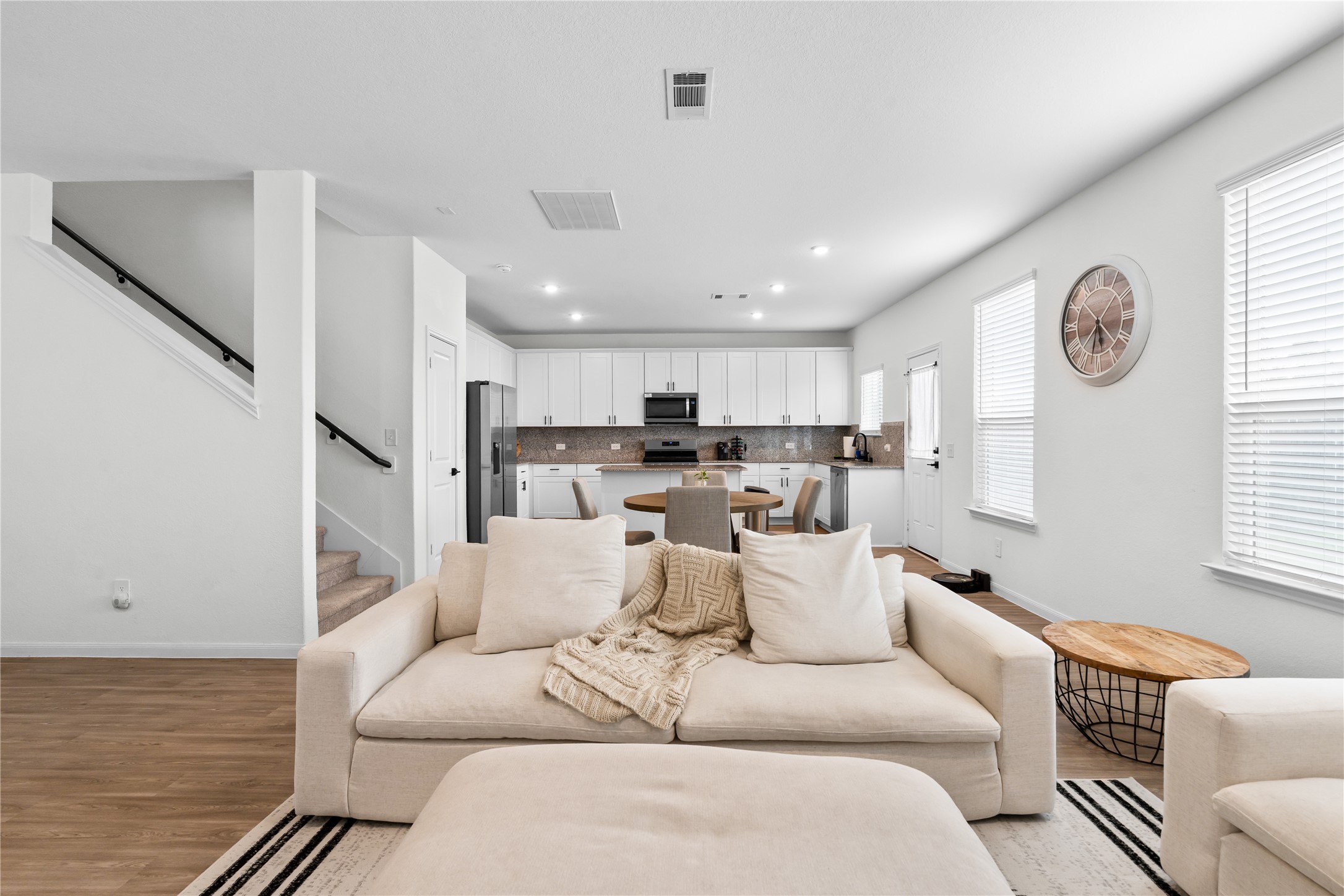Open-concept layout connecting kitchen, living, and stairway