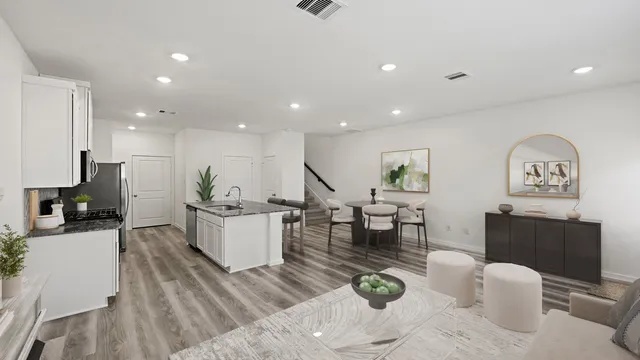 a living room with furniture and kitchen view