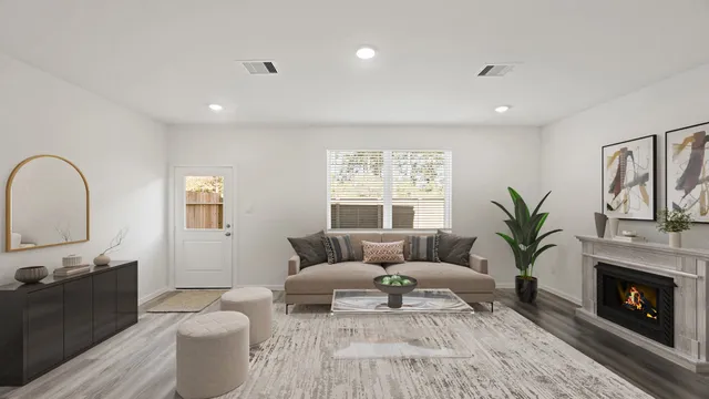 a living room with furniture a fireplace and a potted plant