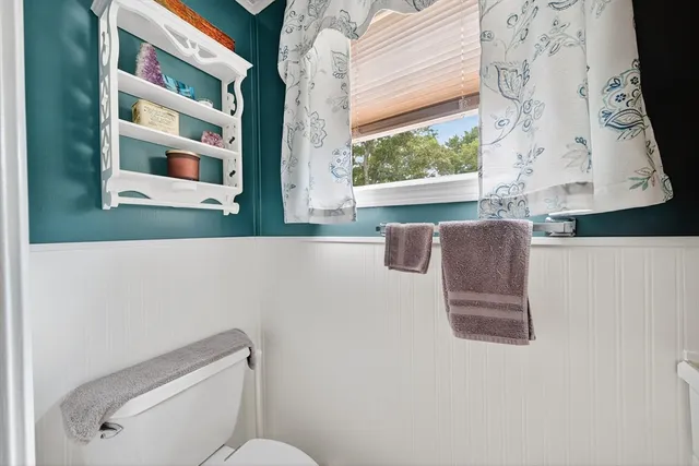 a white toilet sitting next to a window