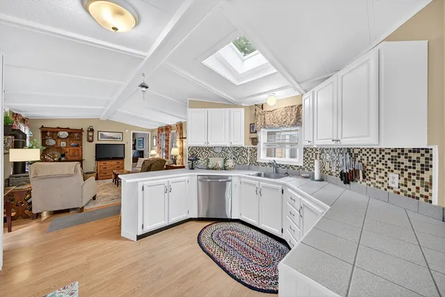 a kitchen with granite countertop a stove a sink and a refrigerator