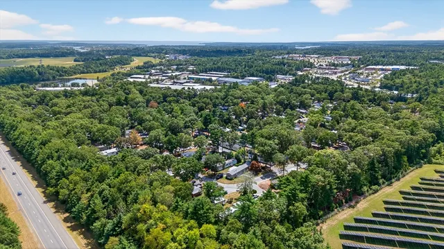 an aerial view of a residential houses with outdoor space and trees