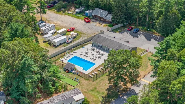 an aerial view of residential house with outdoor space and trees all around