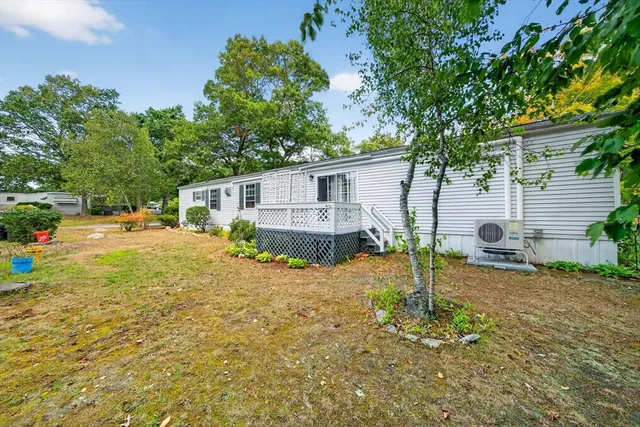a view of a house with backyard and trees