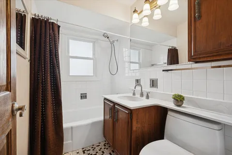 a bathroom with a sink a toilet a mirror a vanity and shower