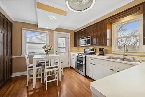 a kitchen with a table chairs microwave and cabinets