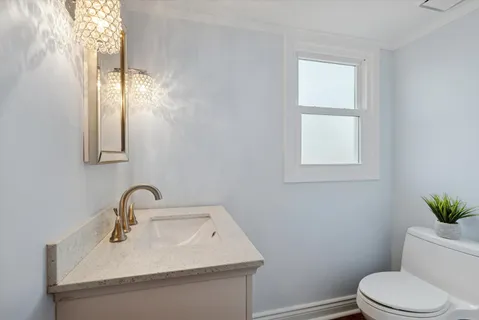 a bathroom with a sink mirror and toilet