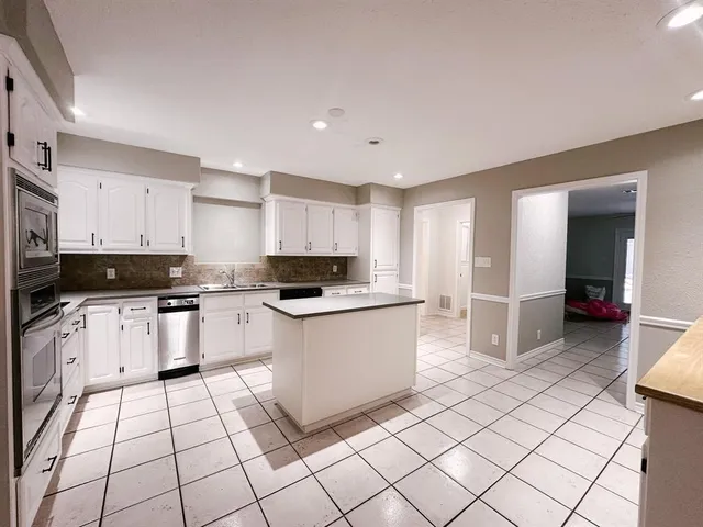 a view of a hallway with wooden floor and windows