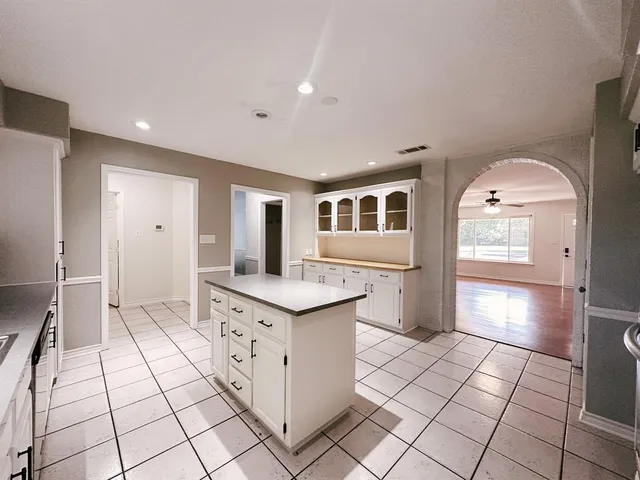 a view of an empty room and chandelier fan