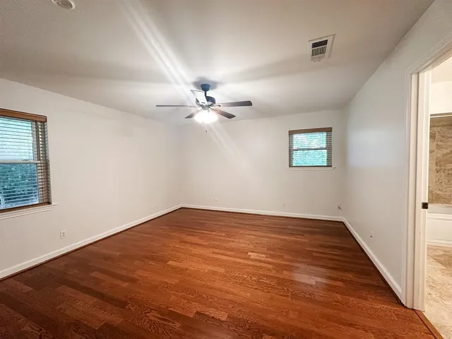 an empty room with a window and a fan