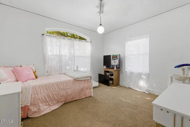 a bedroom with a bed and a television