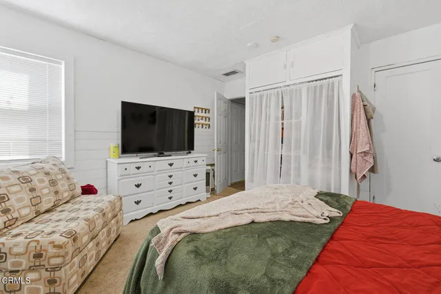 a bedroom with a flat screen tv and a bed