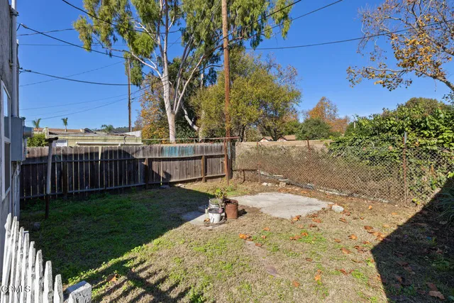 a view of a backyard with wooden fence