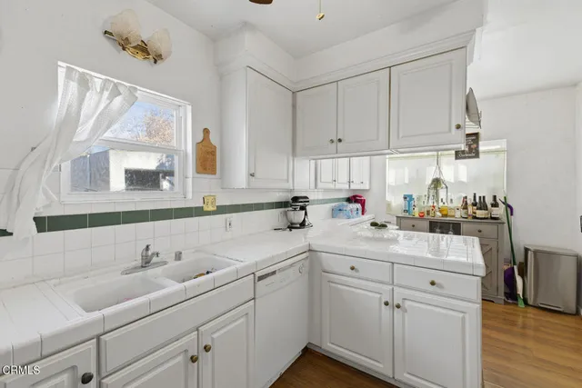 a kitchen with white cabinets and white appliances
