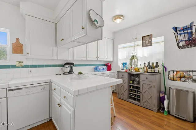 a kitchen with white cabinets and appliances
