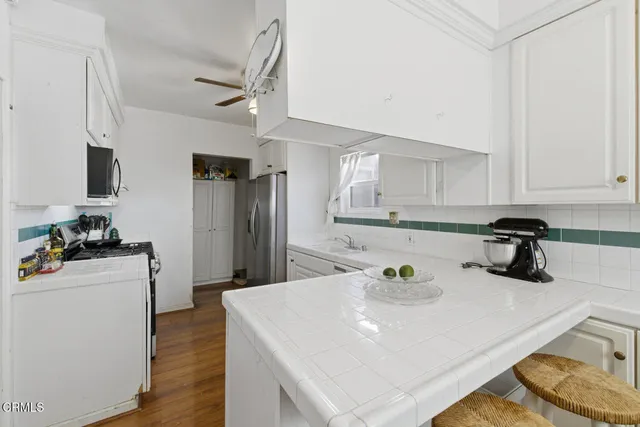 a kitchen with refrigerator and white cabinets