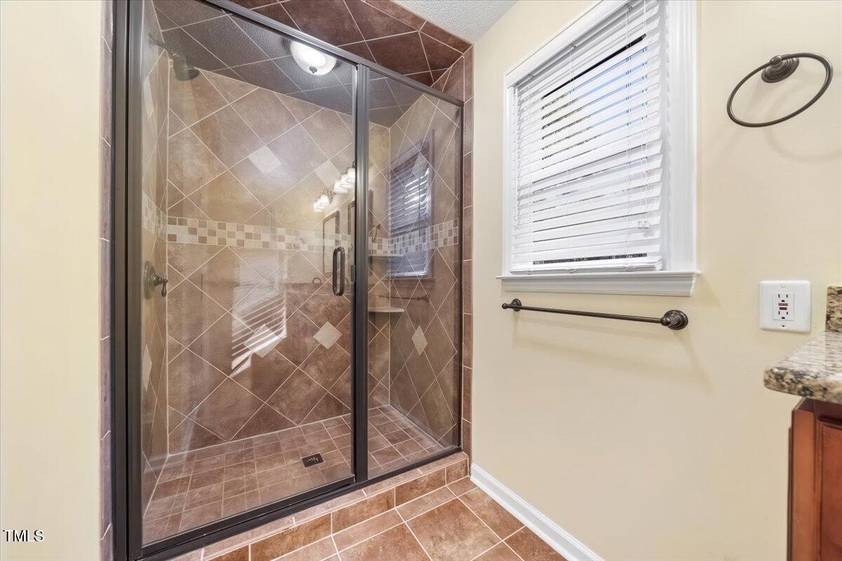 620 Trunecek Circle Raleigh, NC 27603 - Photo 19 of 53 a bathroom with a glass shower door and a window