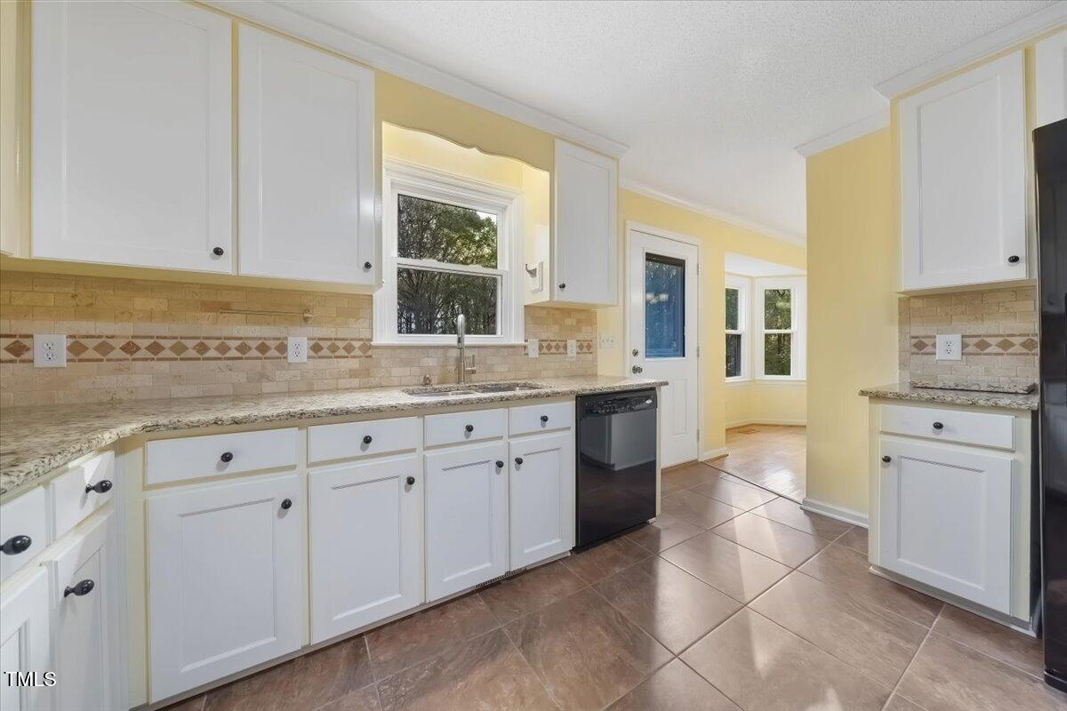 620 Trunecek Circle Raleigh, NC 27603 - Photo 7 of 53 a kitchen with granite countertop a sink white cabinets and stainless steel appliances