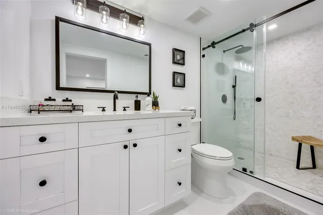 a bathroom with a toilet sink shower and mirror