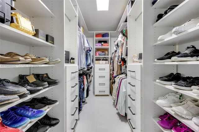 a view of walk in closet with clothes and shoes