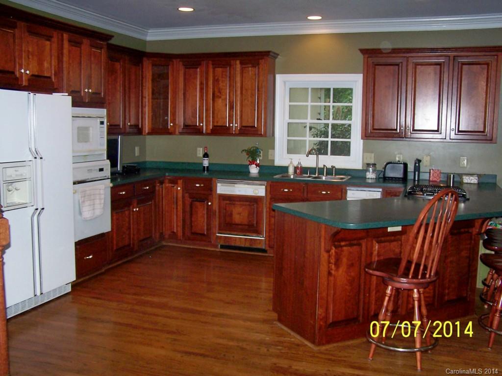 2405 New Salem Road Monroe, NC 28110 - Photo 4 of 20 a kitchen with stainless steel appliances granite countertop a refrigerator a sink dishwasher a stove with wooden cabinets and wooden floor