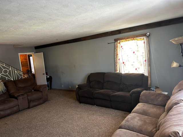 102 South Main Street Paris, ID 83261 - Photo 7 of 33 Carpeted living room with a textured ceiling and baseboards