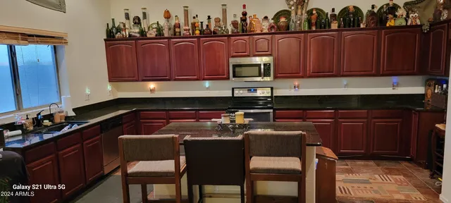 a kitchen with stainless steel appliances granite countertop a refrigerator and wooden cabinets