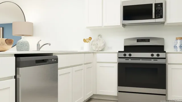 a kitchen with stainless steel appliances a stove microwave and sink