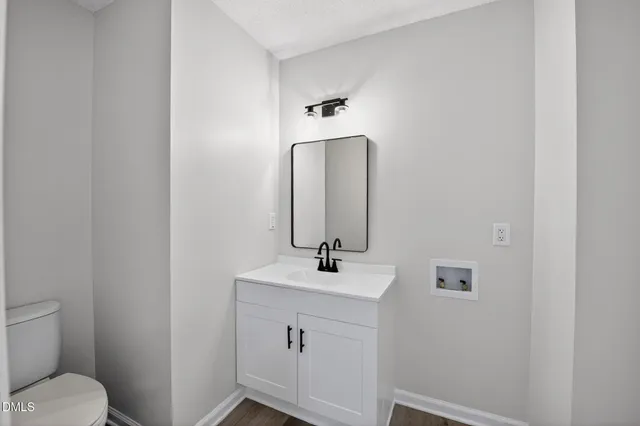 a bathroom with a sink a toilet and a large mirror