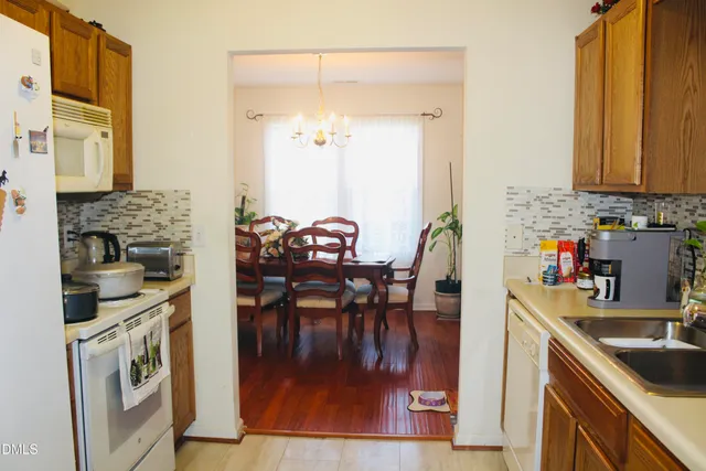 a kitchen with stainless steel appliances granite countertop a stove a sink and a dining table view