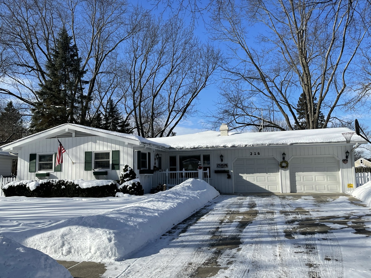 a view of a white house with a large tree