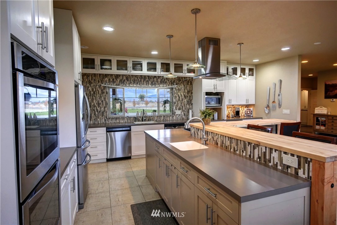 81 Jaquish Road Omak, WA 98841 - Photo 13 of 40 a kitchen with kitchen island granite countertop a sink counter space stainless steel appliances and cabinets
