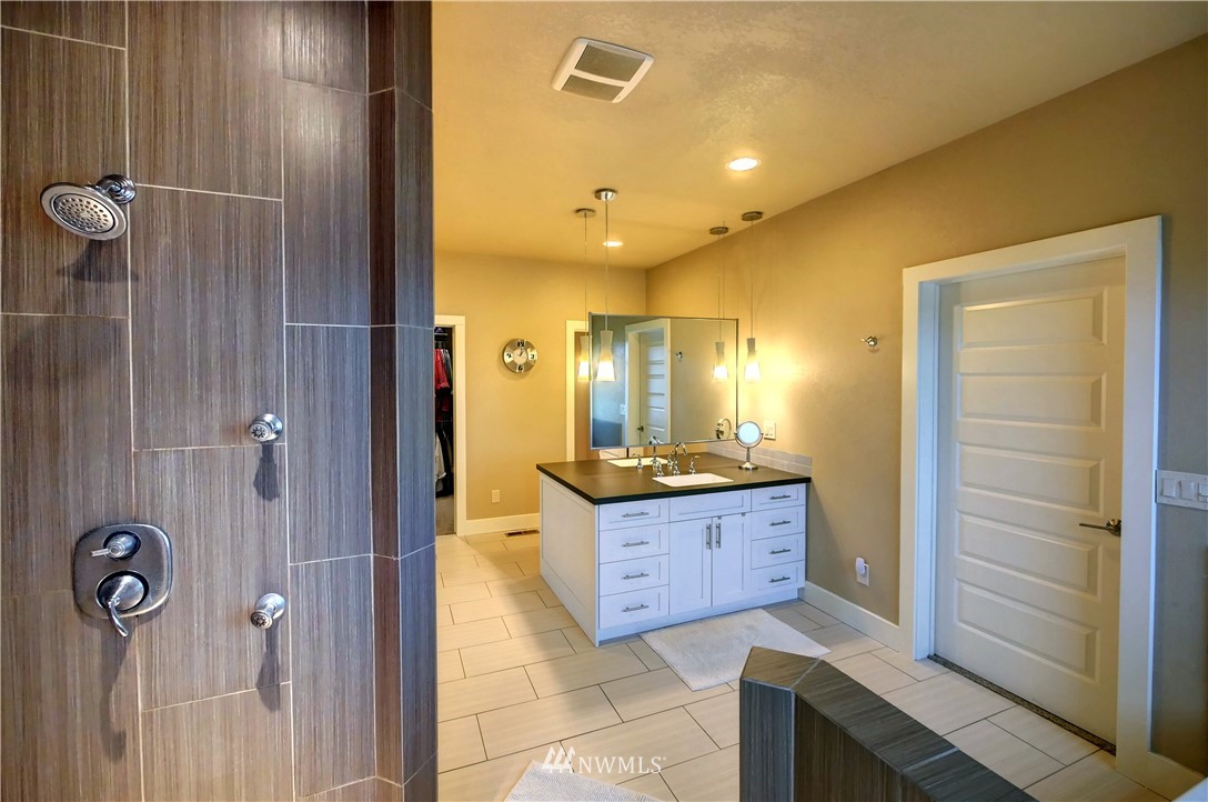 81 Jaquish Road Omak, WA 98841 - Photo 29 of 40 a bathroom with a granite countertop sink a mirror and a shower