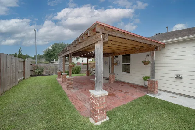 a patio with table and chairs and potted plants