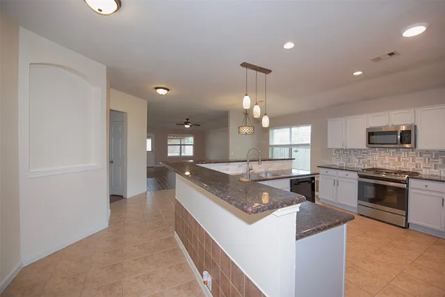 a kitchen with granite countertop a sink and a stove