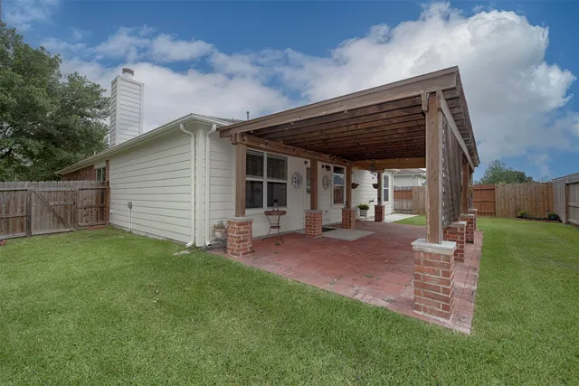 a view of a backyard with chairs and plants