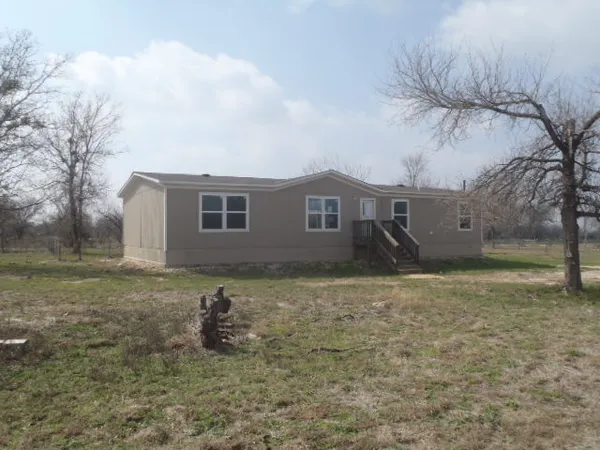 a backyard of a house with table and chairs