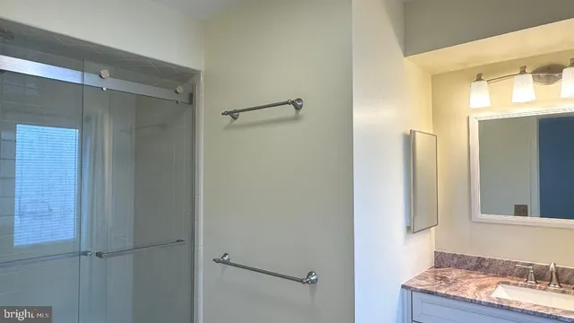 a bathroom with a granite countertop sink mirror and vanity