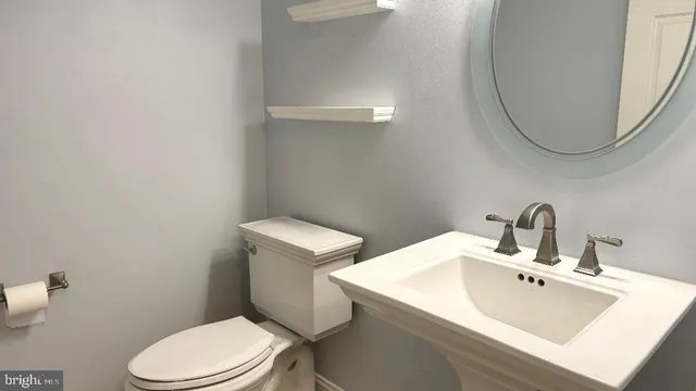 a bathroom with a sink a toilet and a mirror
