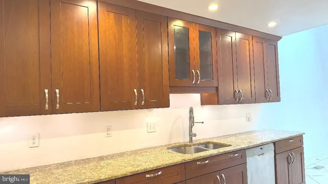 a kitchen with granite countertop wooden cabinets and sink