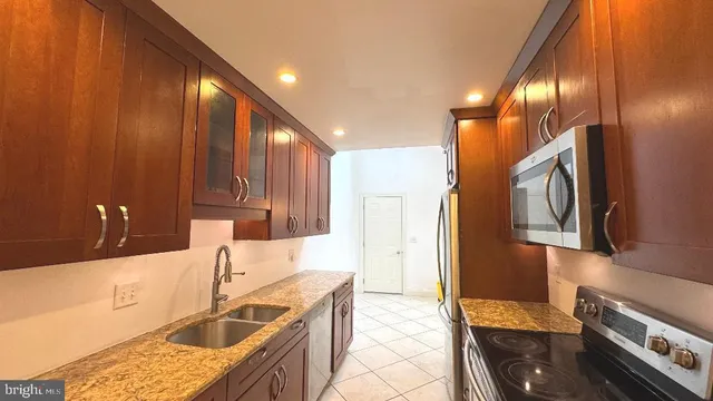 a kitchen with stainless steel appliances granite countertop a sink stove and refrigerator