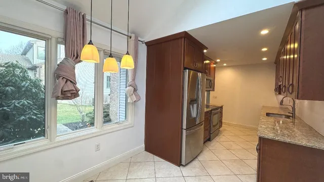 a kitchen with stainless steel appliances granite countertop a refrigerator and a sink