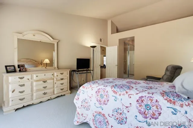 a bedroom with a bed and a dresser in it