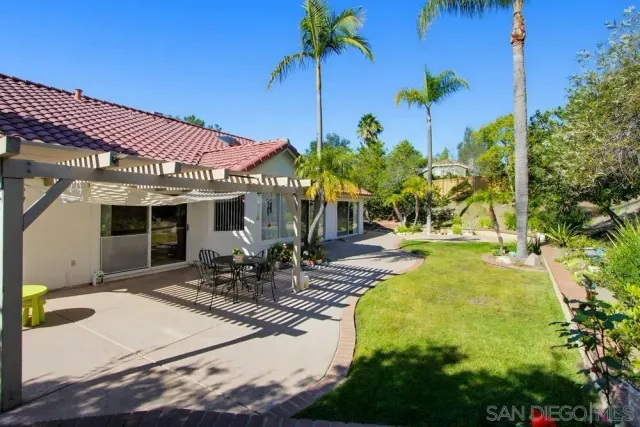 a view of a house with backyard and sitting area
